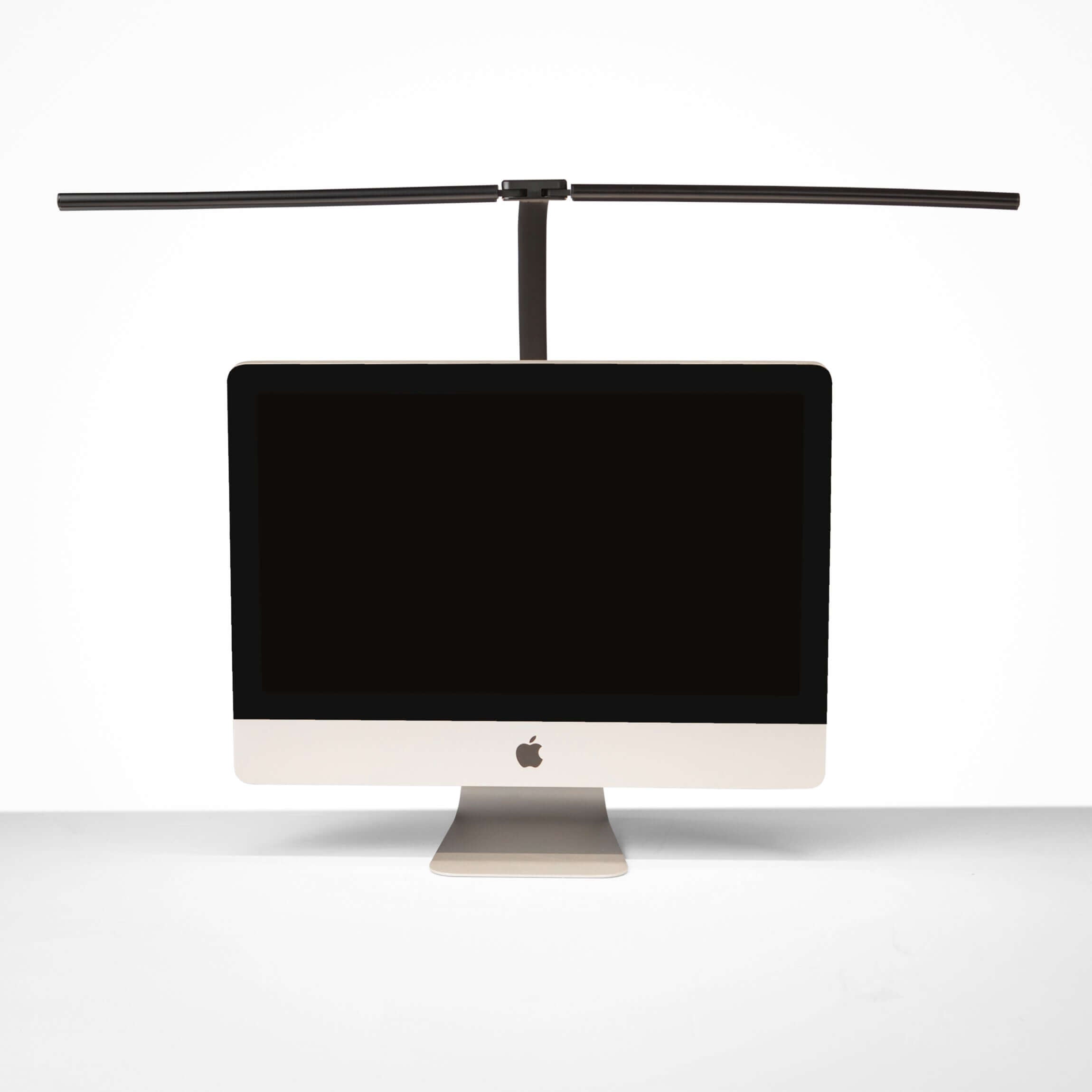 Black DUO LED desk lamp with dual adjustable light heads shown on a workstation with a computer monitor.