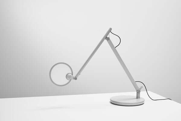 Modern white Nova desk lamp with adjustable arm on a desktop base, offering adaptable, glare-free LED lighting for workspaces.