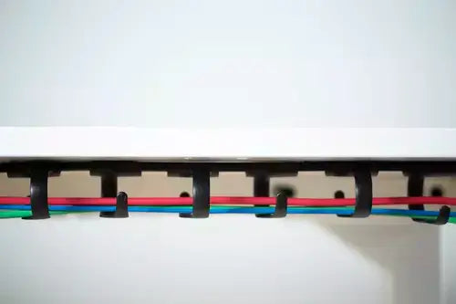 RIB cable tray under tabletop with colorful cables, organizing wires neatly and universally compatible with all desk types.