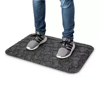 Standing on a grey ergonomic workstation mat for comfort and support