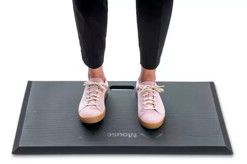 Person standing on ergonomic Mousetrapper Active workstation mat with sneakers