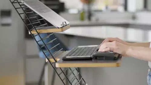 Ergonomic Standfriend in light grey enhances workspace by allowing easy transition between sitting and standing positions.