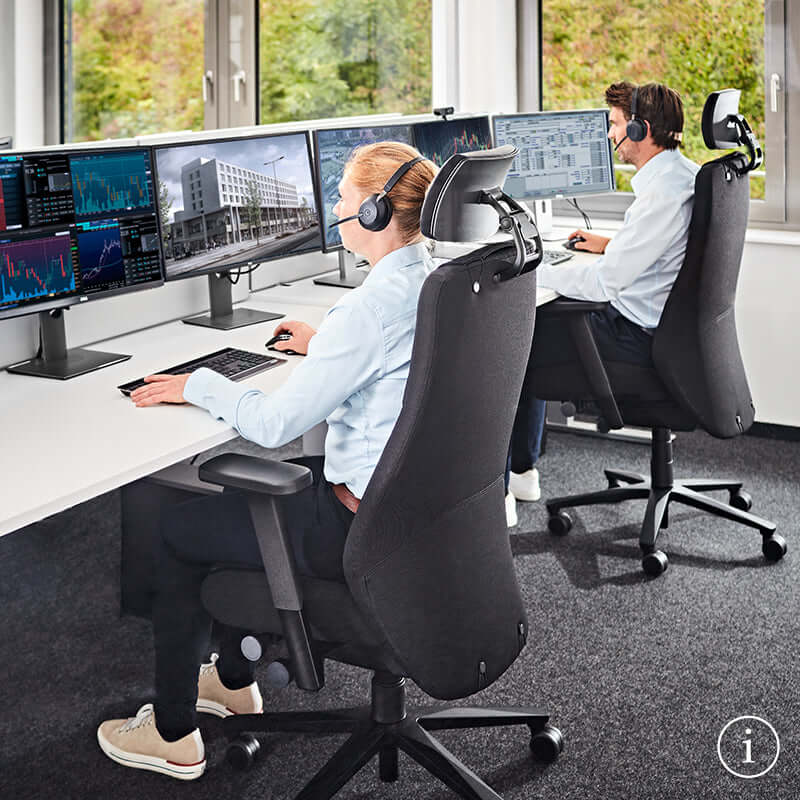 People sitting in TWENTYFOURis5 control room chairs with adjustable ergonomic features, working at computer monitors in an office setting.