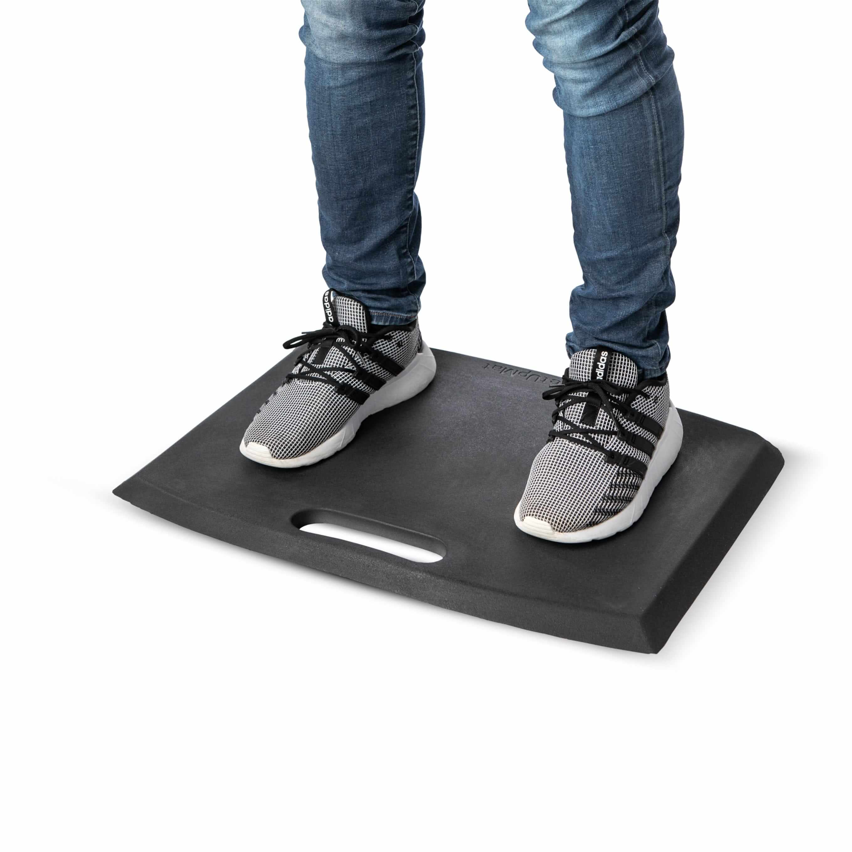 Person standing on GetUpMat workstation mat with carrying handle, grey, designed for ergonomic comfort in various work environments.