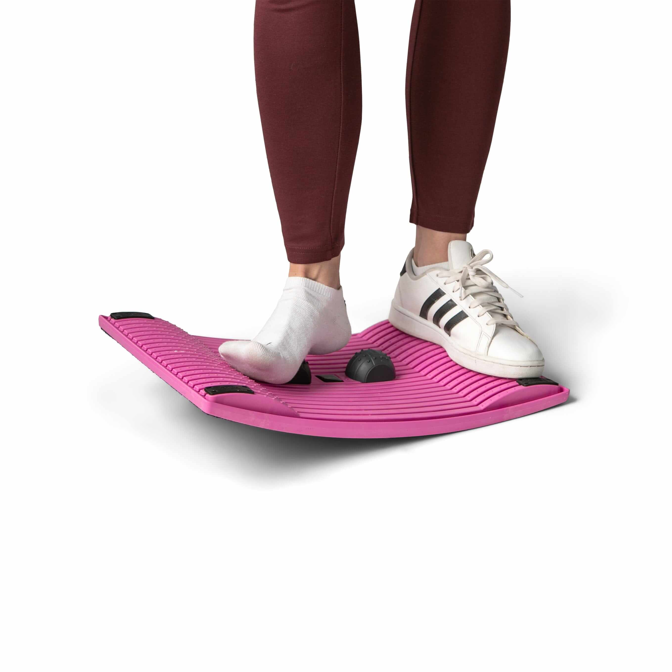 Person using pink Gymba activation board for movement and fitness at the workplace.