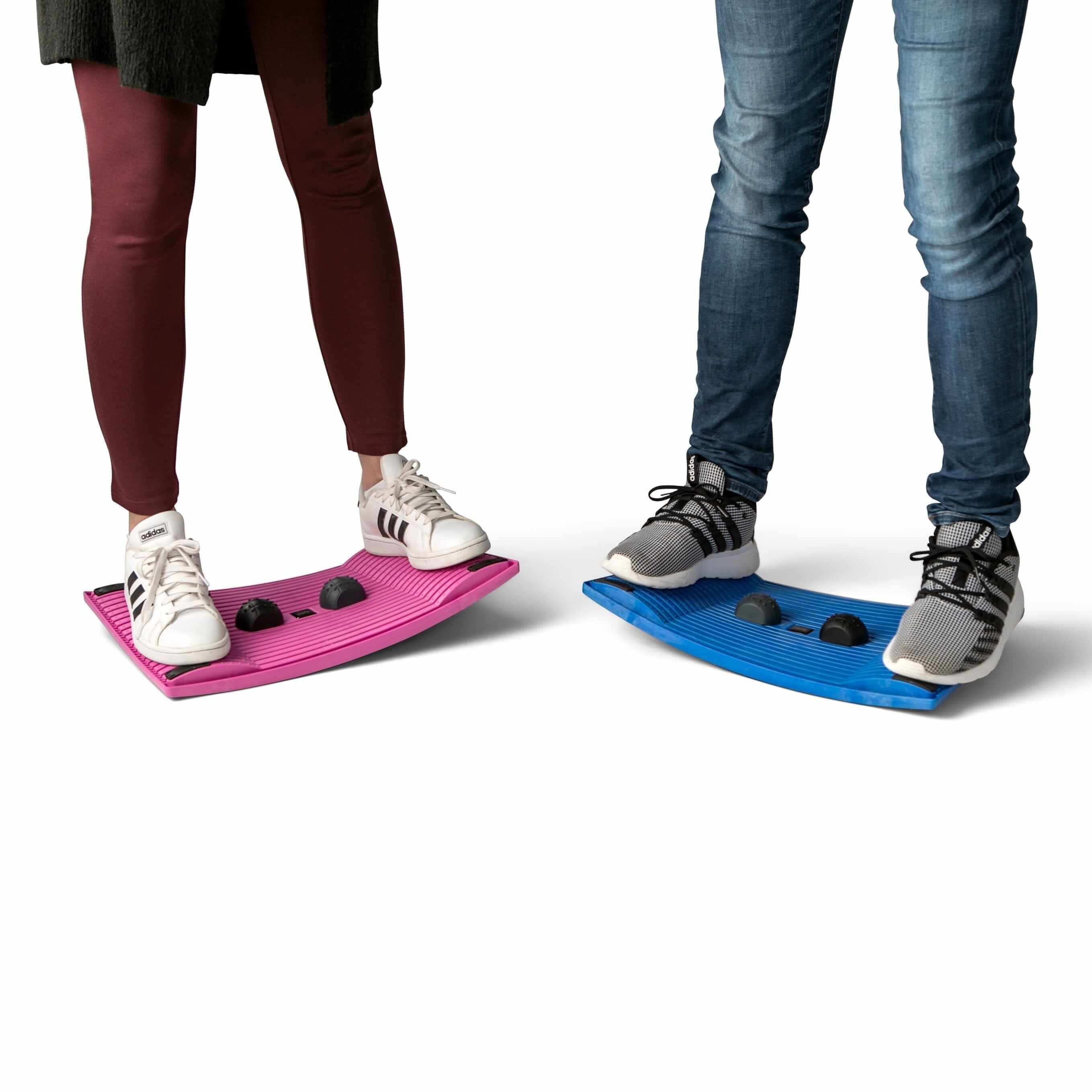 Two people balancing on pink and blue Gymba activation boards, promoting movement and improved concentration at the workplace.